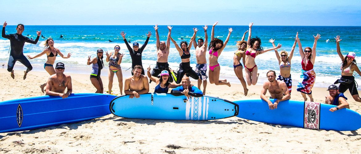 Surfing students jumping for joy after first lesson